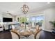 A dining room with a round table, chandelier, and sliding doors to the deck with water views at 7115 Bay St, St Pete Beach, FL 33706