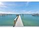 Wooden dock extending into the water, offering a peaceful setting with clear skies and waterfront views at 7115 Bay St, St Pete Beach, FL 33706