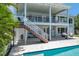 Rear exterior featuring a pool and a covered patio with staircase at 7115 Bay St, St Pete Beach, FL 33706