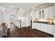 Hallway with stairs, built-in cabinets with glass doors, and wood flooring at 7115 Bay St, St Pete Beach, FL 33706