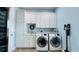Well-organized laundry room with white cabinets, sink, marble countertop, and modern Samsung washer and dryer at 7115 Bay St, St Pete Beach, FL 33706