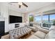 Living area with custom built-ins, a ceiling fan, and sliding glass doors with water views at 7115 Bay St, St Pete Beach, FL 33706