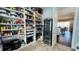 Spacious pantry featuring custom shelving, storage baskets, and a wine fridge for beverages and kitchen appliances at 7115 Bay St, St Pete Beach, FL 33706