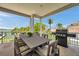 Spacious outdoor patio with a dining table, grill, and waterfront views, ideal for entertaining at 7115 Bay St, St Pete Beach, FL 33706