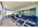 Large covered patio with dining and lounge area, seamlessly blending indoor and outdoor living with waterfront views at 7115 Bay St, St Pete Beach, FL 33706