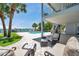 Inviting outdoor patio with comfortable seating, a swimming pool, and views of the waterfront at 7115 Bay St, St Pete Beach, FL 33706
