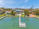 Back of home featuring a private dock, pool, and lush landscaping creating a luxurious waterfront retreat at 7115 Bay St, St Pete Beach, FL 33706