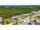 Aerial view of a waterfront home, with a dock, firepit, surrounded by lush greenery at 825 Seabreeze Dr, Ruskin, FL 33570