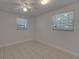 A simple bedroom with bright lighting from two windows and tile flooring at 825 Seabreeze Dr, Ruskin, FL 33570