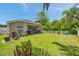 Spacious backyard featuring a covered patio, lush green lawn, and privacy fence, perfect for outdoor living at 8504 Tidal Bay Ln, Tampa, FL 33635