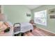 Comfortable bedroom with a large window, light green paint, and wood-look floors at 8504 Tidal Bay Ln, Tampa, FL 33635