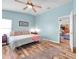 Comfortable bedroom featuring wood floors, a ceiling fan, light blue walls, and decoratively matching linens and pillows at 8504 Tidal Bay Ln, Tampa, FL 33635