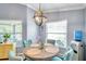 Dining area with modern light fixture, round table and natural light from windows at 8504 Tidal Bay Ln, Tampa, FL 33635