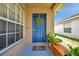 Cozy front porch with a vibrant blue door, decorative wreath, and charming welcome mat at 8504 Tidal Bay Ln, Tampa, FL 33635