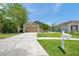 Single-story home with a well-maintained lawn, landscaping and long driveway at 8504 Tidal Bay Ln, Tampa, FL 33635