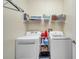 Functional laundry room with washer, dryer, storage shelves, and ample space for laundry tasks at 8504 Tidal Bay Ln, Tampa, FL 33635