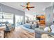 Inviting living room featuring wood floors, ceiling fan, and sliding glass doors to outdoor area at 8504 Tidal Bay Ln, Tampa, FL 33635