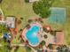 Overhead shot shows community pool with playground and basketball court, surrounded by lush landscaping and red mulch at 8504 Tidal Bay Ln, Tampa, FL 33635