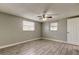 A bright, empty bedroom with modern tile floors, neutral walls, a ceiling fan, and natural lighting at 9120 Lunar Ln, Port Richey, FL 34668