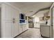 Modern kitchen with white cabinets, stainless steel appliances, and tile flooring, offering a clean and functional space at 9120 Lunar Ln, Port Richey, FL 34668