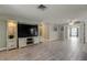 Spacious living room with custom built-in shelving, modern tile floors, and an open layout, perfect for entertaining at 9120 Lunar Ln, Port Richey, FL 34668