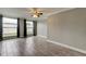 Inviting living room with large windows, modern tile flooring, ceiling fan, and neutral paint, offering a comfortable living area at 9120 Lunar Ln, Port Richey, FL 34668
