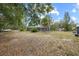 Large backyard featuring a screened-in pool area and lush trees at 9615 Jasmine Blvd, New Port Richey, FL 34654
