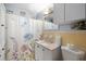 Quaint bathroom with a floral shower curtain, vanity, and bright accents, radiating a cheerful vibe at 9615 Jasmine Blvd, New Port Richey, FL 34654