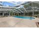 Screened pool with brick patio, perfect for outdoor entertaining, and surrounded by trees at 9615 Jasmine Blvd, New Port Richey, FL 34654
