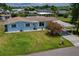 Quaint single-story blue home featuring a well-manicured lawn, carport, and waterfront access at 103 W North Branch Rd, Ruskin, FL 33570