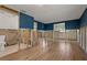 Partially renovated living room showing exposed framing, new flooring, and blue accent walls at 103 W North Branch Rd, Ruskin, FL 33570