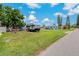 View of the spacious yard with lush green grass, mature trees, and RV parking at 103 W North Branch Rd, Ruskin, FL 33570