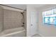 Tiled tub and shower with a stained glass window in the bathroom at 10431 Frog Pond Dr, Riverview, FL 33569