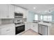 Modern kitchen with stainless steel appliances, white cabinetry and backsplash at 10431 Frog Pond Dr, Riverview, FL 33569
