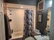Well-lit bathroom with a shower-tub combo, decorated with modern fixtures and a beach-themed accent at 10539 Parkcrest Dr, Tampa, FL 33624