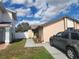 Cozy single-story home featuring a tidy front yard, a paved walkway, and a parked car along the side at 10539 Parkcrest Dr, Tampa, FL 33624