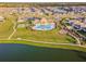 Gorgeous aerial view showcasing community amenities, including a sparkling pool, clubhouse, and lush landscaping at 10822 Crushed Grape Dr, Riverview, FL 33578