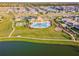 Stunning aerial view of community amenities, including a pool, clubhouse, and scenic pond at 10822 Crushed Grape Dr, Riverview, FL 33578