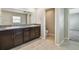 Bathroom with double vanities featuring granite countertops, dark cabinets, and tiled floors at 10822 Crushed Grape Dr, Riverview, FL 33578