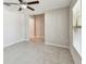 Well-lit bedroom with tiled flooring, a ceiling fan, and a glimpse into the hallway at 10822 Crushed Grape Dr, Riverview, FL 33578