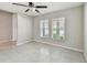 Spacious bedroom with neutral tones, tiled floors, and two windows, offering a serene environment at 10822 Crushed Grape Dr, Riverview, FL 33578