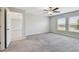 Bright bedroom featuring plush carpet, a ceiling fan, and natural light from two windows at 10822 Crushed Grape Dr, Riverview, FL 33578