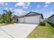 Single-story home featuring a spacious driveway, lawn, and landscaping at 10822 Crushed Grape Dr, Riverview, FL 33578