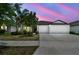 Charming single-story home featuring a spacious driveway and well-maintained landscaping at dusk at 10822 Crushed Grape Dr, Riverview, FL 33578