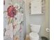 Charming bathroom with a floral shower curtain, built-in shelving, and a standard toilet for a complete and functional space at 1116 Hillandale Reserve Dr, Tampa, FL 33613