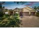 Charming home featuring a paver driveway, well-manicured lawn, and a three-car garage at 1116 Hillandale Reserve Dr, Tampa, FL 33613