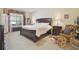 Elegant main bedroom featuring a dark wood bed, an abundance of natural light, and a comfortable sitting area at 1116 Hillandale Reserve Dr, Tampa, FL 33613