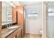 Bathroom with wooden cabinets, granite counters, and a clear glass walk-in shower at 11250 108Th Ln, Largo, FL 33778