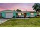 A charming home featuring a well-kept lawn, a garage, and solar panels for energy efficiency at 11250 108Th Ln, Largo, FL 33778