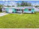 Charming turquoise home with a well-manicured lawn, solar panels, and a one-car garage at 11250 108Th Ln, Largo, FL 33778